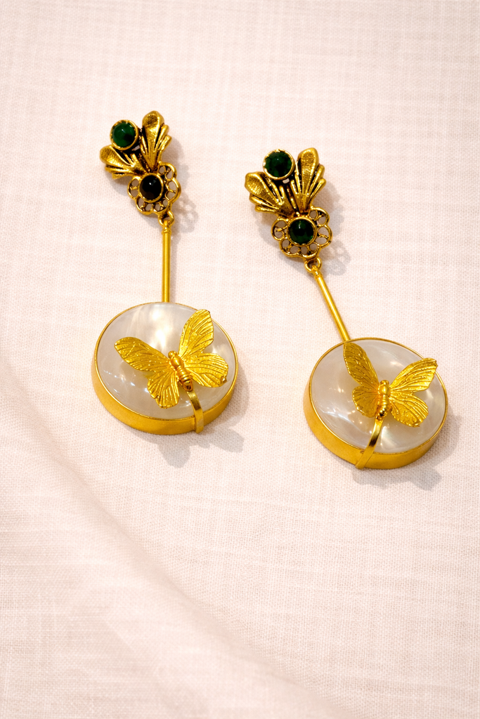 ترجمتها إلى العربية: أقراط فراشة بحلية أوبال أبيض بلونٍ ذهبي